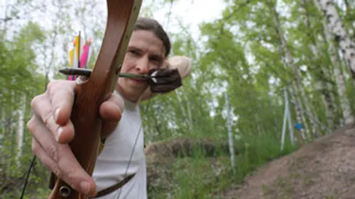 Bogen aims at a target in the forest, quiet area.