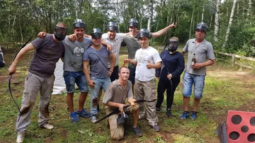 Gruppe von Menschen in Schutzkleidung, die Waffen halten, im Wald.