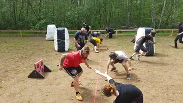 Teilnehmer ziehen an einem Seil auf einem Trainingsgelände.