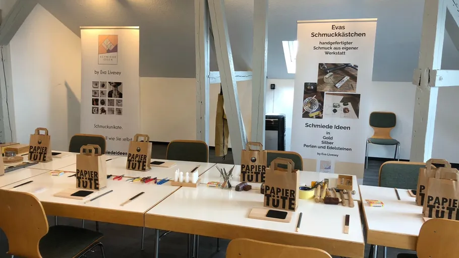 Tische mit Werkzeugen und Materialien für kreativen Schmuckbau.