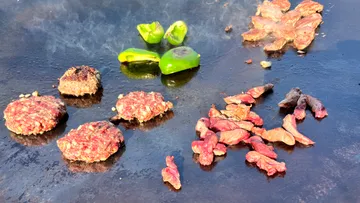Rohes Fleisch und Paprika braten auf einer heißen Platte.