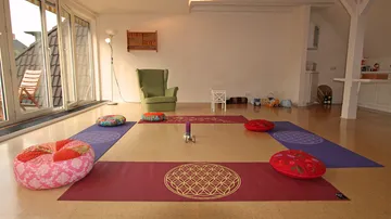 Kissen und Matten stehen bereit für eine Meditationssitzung.