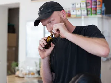 Ein Mann benutzt eine Flasche in einem hellen Raum.