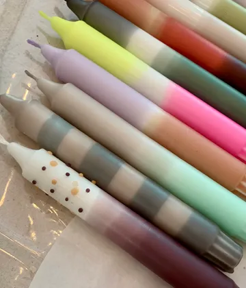 Bunte Kerzen liegen nebeneinander auf einer Oberfläche.