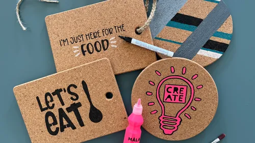 Cork coasters with inscriptions and craft materials on table