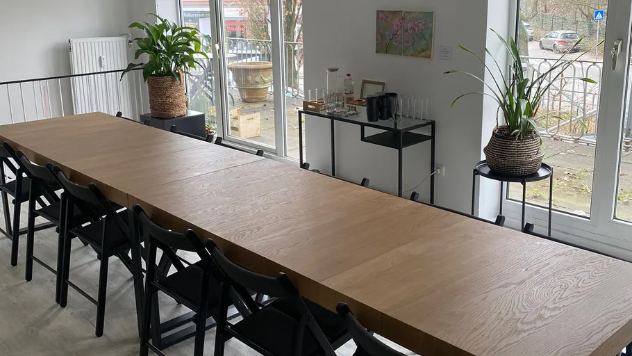 Long wooden table with chairs in a bright room.