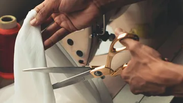 Schneider cuts fabric with golden scissors.