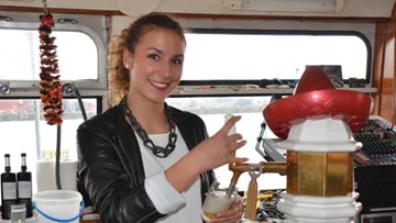 Frau zapft Bier an einer Bar auf einem Boot.