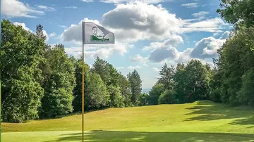 Golfflagge weht sanft auf einem gepflegten Golfplatz.
