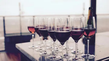 Gläser mit Wein stehen auf einem Tisch in einer eleganten Umgebung.