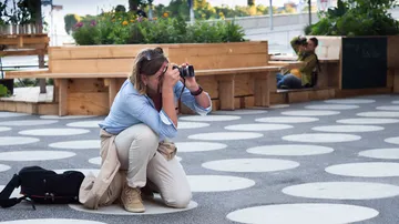 Frau fotografiert in einem urbanen, gepflasterten Raum.
