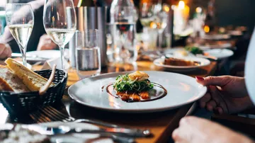 Ein Teller mit Essen wird am Tisch serviert.