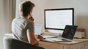 Man sitting at a desk, concentrating on computer screen.