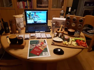 Laptop mit Kochzutaten und Gewürzen auf einem Tisch.