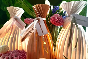Three decorative lamps shine softly in a floral decoration.