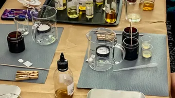 Cups and bottles mix oils on a work table.
