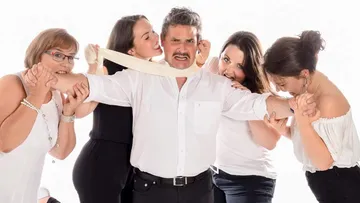 Man is challenged and held by several women.