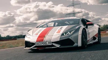 Lamborghini drives fast on a winding road.