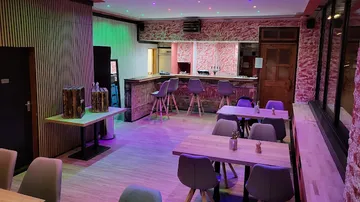 Moderne Bar mit Tischen, Stühlen und bunten Lichtern.