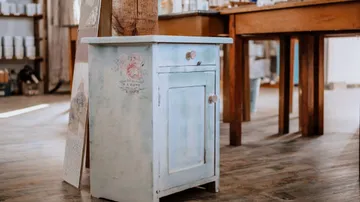There is a small, blue table with a drawer in the room.