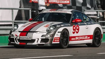Race car drives fast on a racetrack.