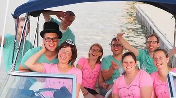 Group of friends happily posing on a boat.