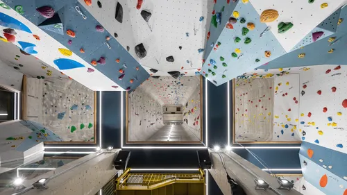 Kletterwand in Halle; Kletterer bewegt sich vertikal in der Höhe.