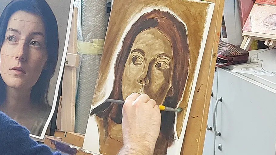 Artist painting a woman's portrait indoors.
