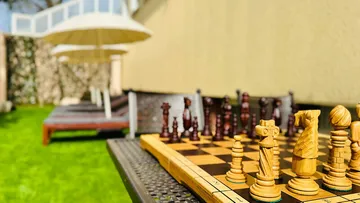 Chess game on a table in the garden, relaxing environment.