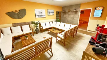 Gemütliche Sitzecke mit Holzsofas in orangefarbenem Raum.
