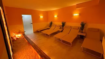 Relaxed loungers are set in an orange spa room.