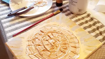 Canvas is processed with textured paint. Artistic activity at the table.