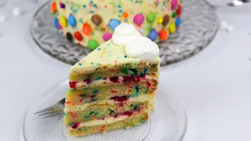 Colourful cake with cream served in elegant surroundings.
