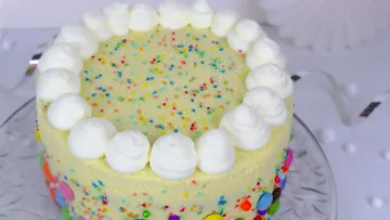 Eine bunte Torte mit Sahnehaube und Streuseln.