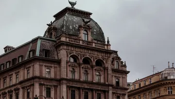 Historic building with an elaborate roof structure, under grey skies.