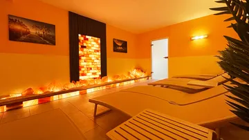 Quiet room with loungers and orange wall lighting.