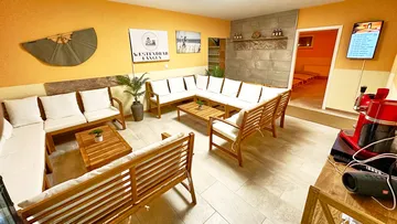 Gemütlicher Raum mit Sofas, Pflanzen und Technik.