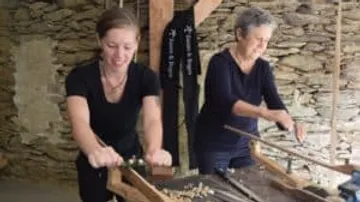 Two women work together on craft activities.