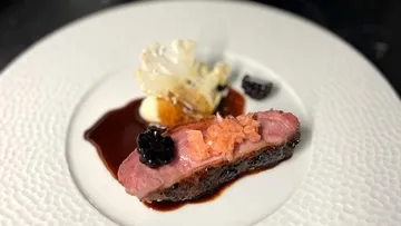 Ein Stück Fleisch liegt auf einem eleganten Teller.