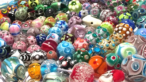 Colourful glass beads lie close together on the surface.