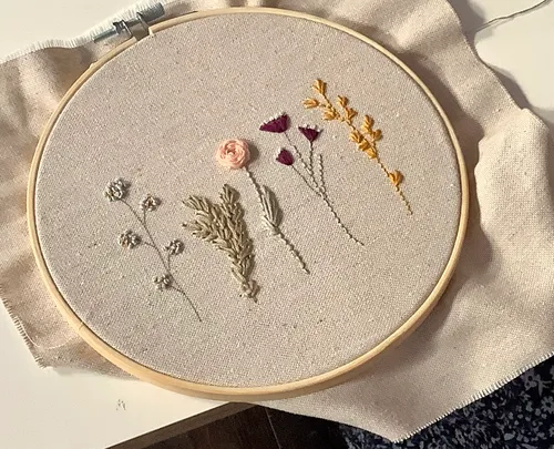 Embroidery hoop with floral designs on fabric.