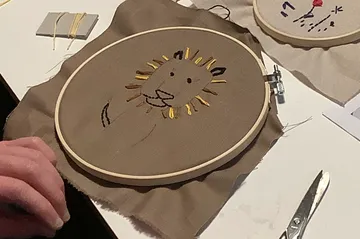Löwenstickerei in einem Rahmen auf dem Tisch.