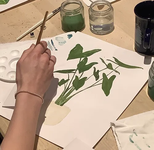 Handbemalung von grünen Blättern auf Papier.