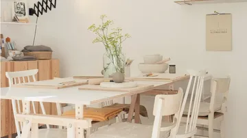 Wooden table with crockery and flowers in a bright room.