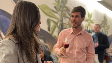 Frauen und Männer unterhalten sich in einer Weinstube.
