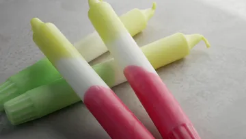 Colourful marker pens lie on a bright background.