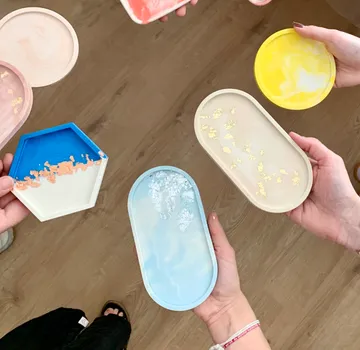 Colourful bowls are held by hands, wooden floors visible.