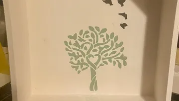 Grüner Baum mit Herz, schwebenden Vögeln, neutralem Hintergrund.