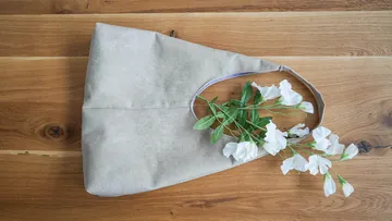 A bag with flowers on a wooden background.