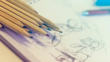 Pencils lie on sketchpad, draw figures in motion.